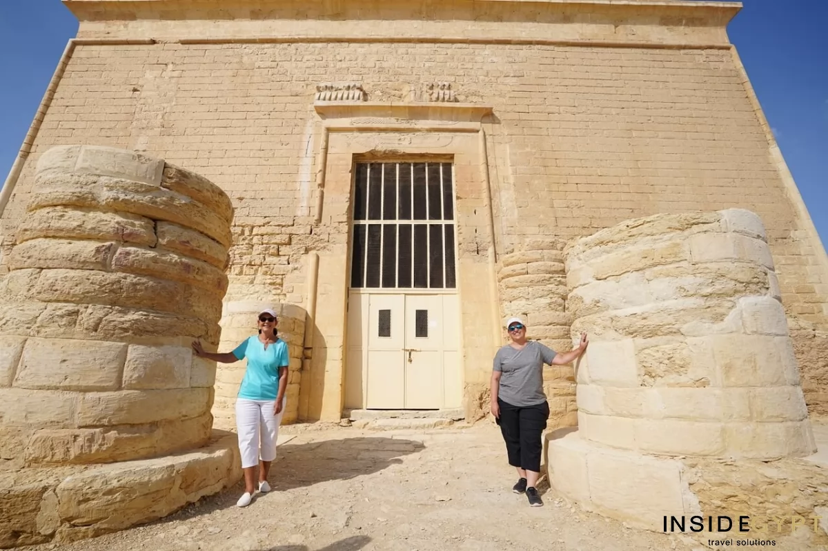 Two tourists posing for a picture in front of the Qasr Qaroun Temple at Fayoum 