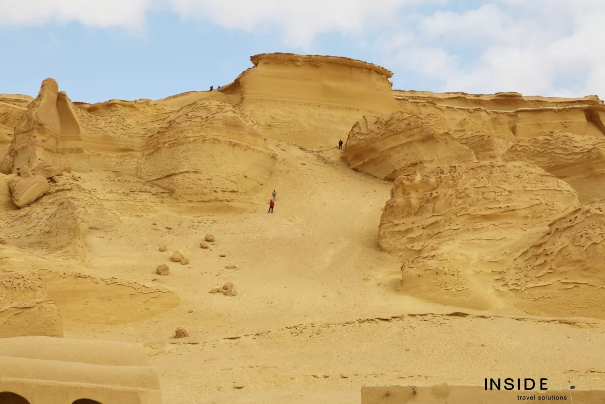 Tourists climbing dunes in the valley of the Whales in Egypt
