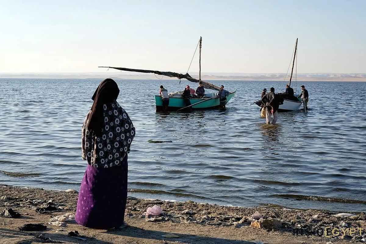 Egyptian woman watching fishermen in the Fayoum Oasis 