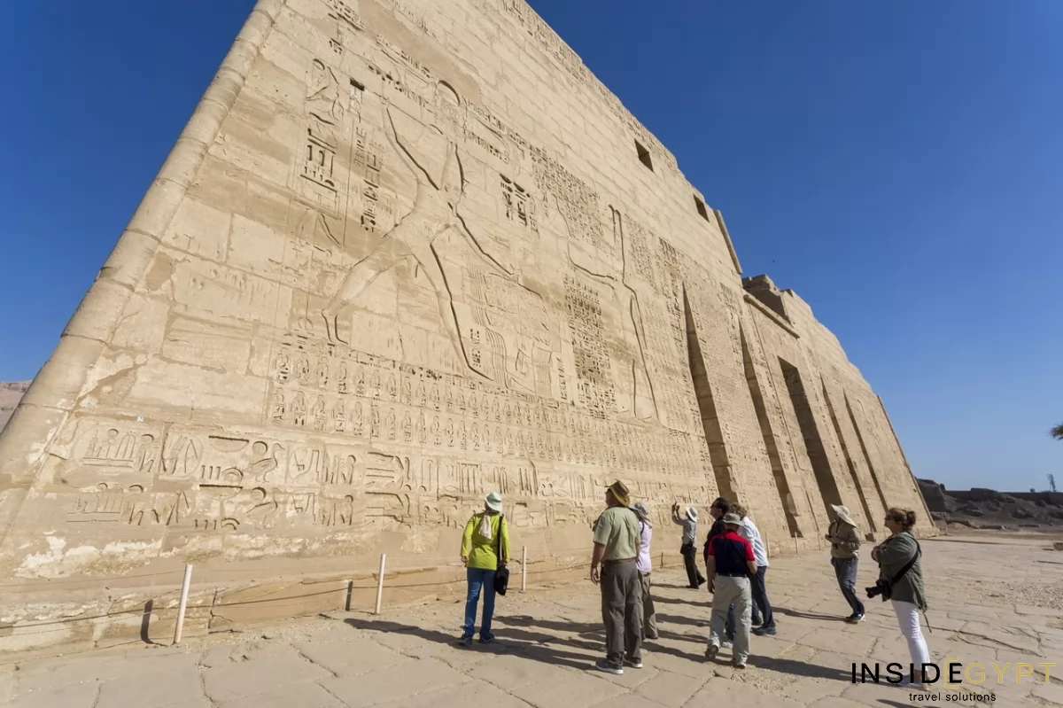 Tourists admiring the hieroglyphs in the Medinet Habu 