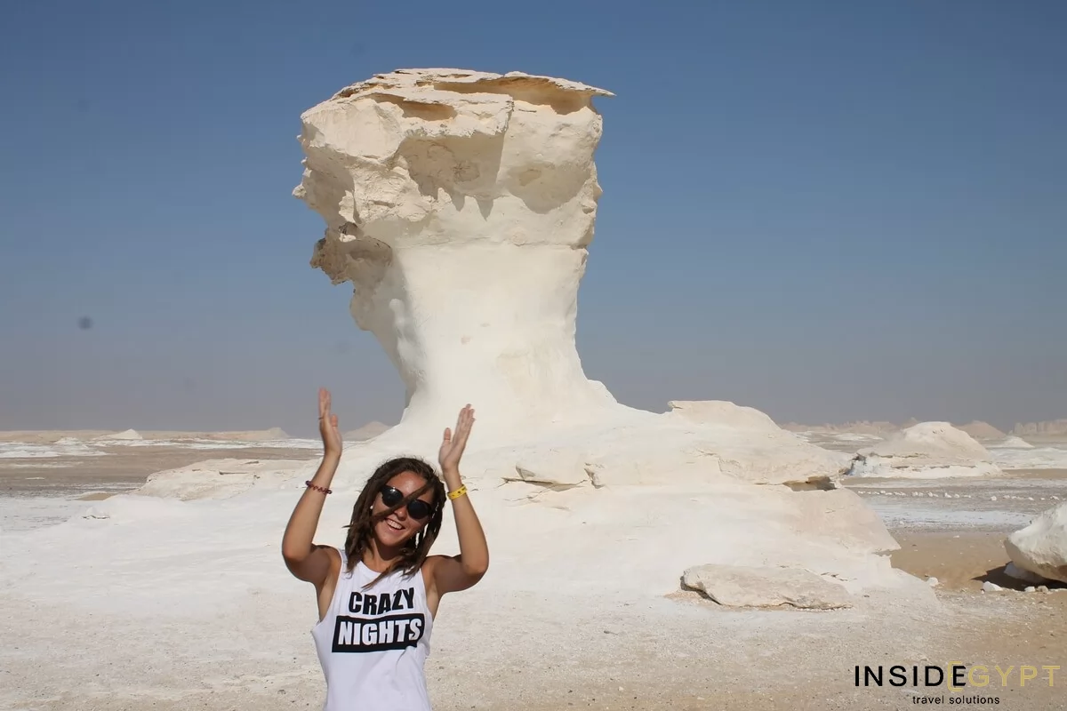 Tourist near a mushroom-like rocky formation in the White Desert