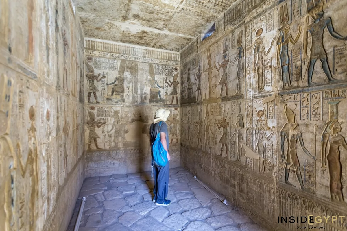 Tourist looking at Egyptian hieroglyphics at the Medinet Habu site 