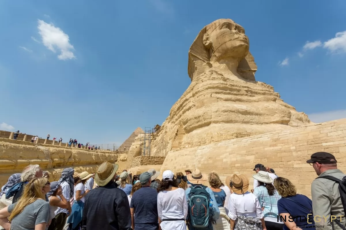 Experience the wonders of Egypt with a private tour of the Giza Pyramids and Sphinx, as this group of tourists marvel at the majestic Sphinx. 